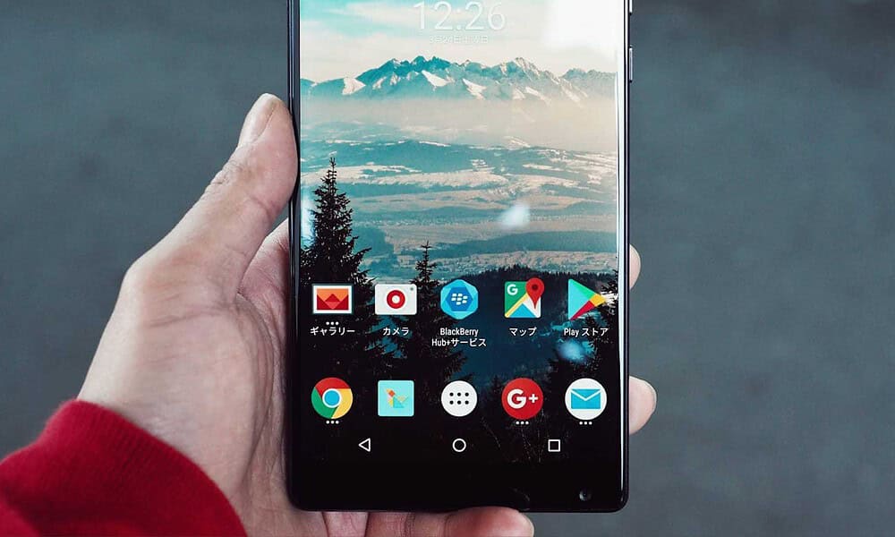 A person holding a phone looking at the android apps.