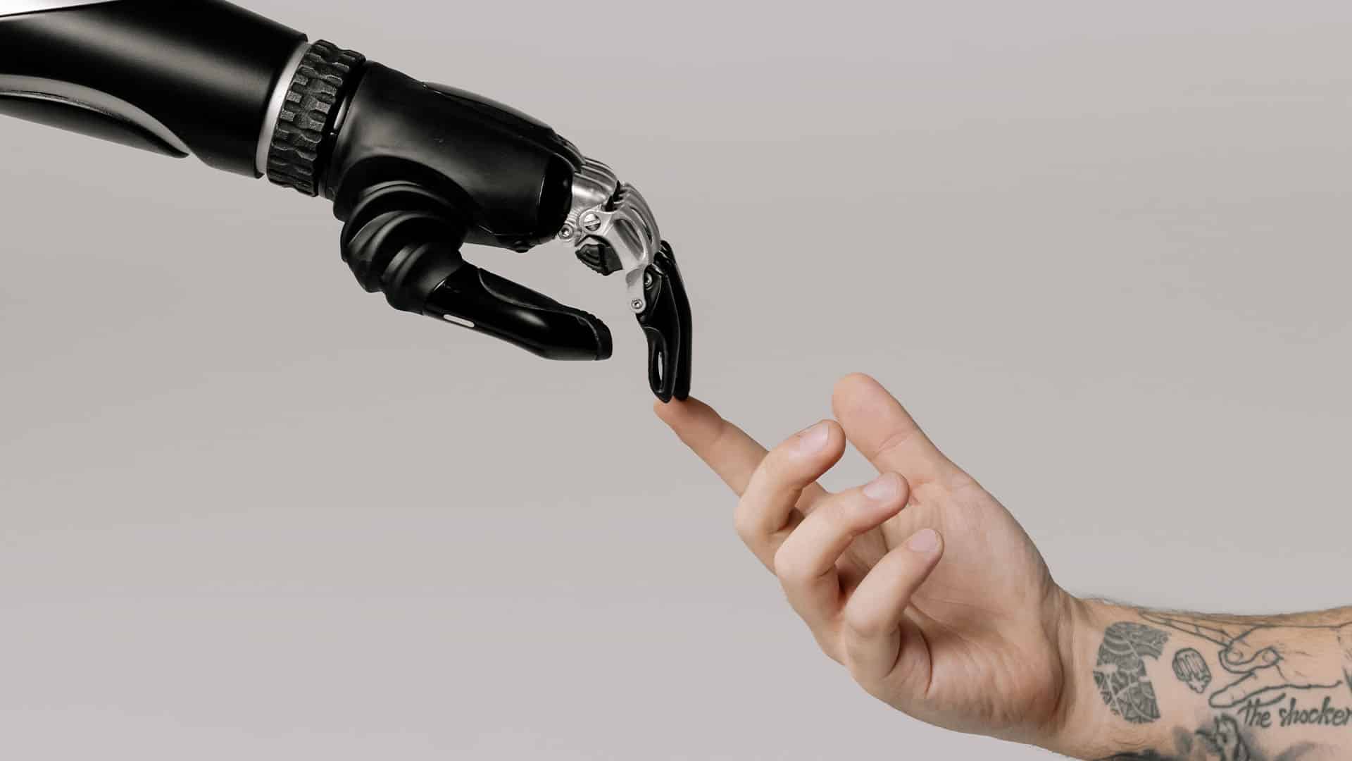 A robot hand is touching a human hand.