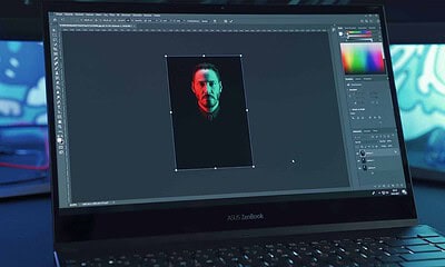 The laptop screen displays a image being photo editing