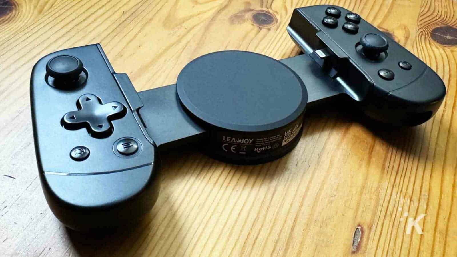 A joystick and game controller with a lever are being used indoors.
