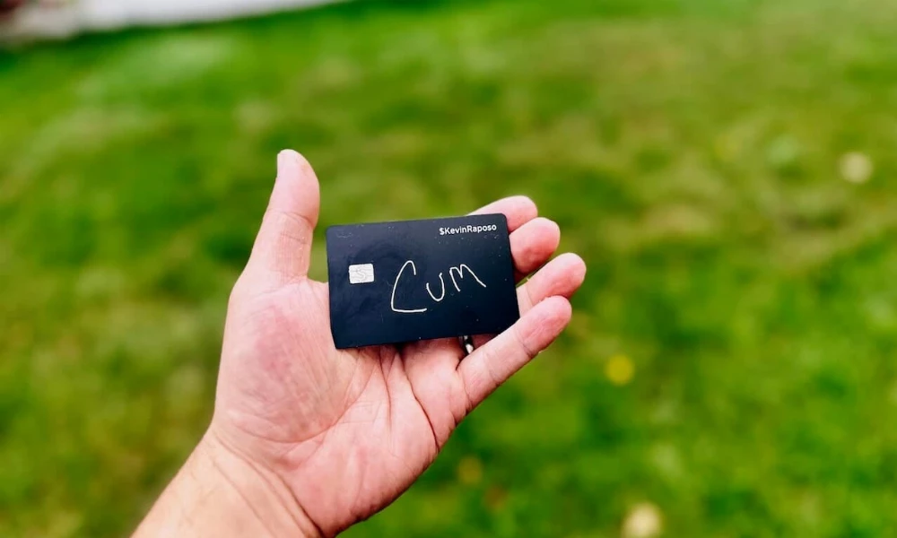 A person holding a credit card that reads cum on it