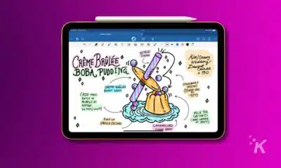 apple ipad with an apple pencil laid on top of it hovering over a purple background