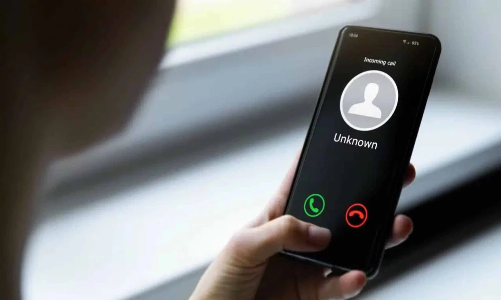 A person holds a phone with an unknown caller
