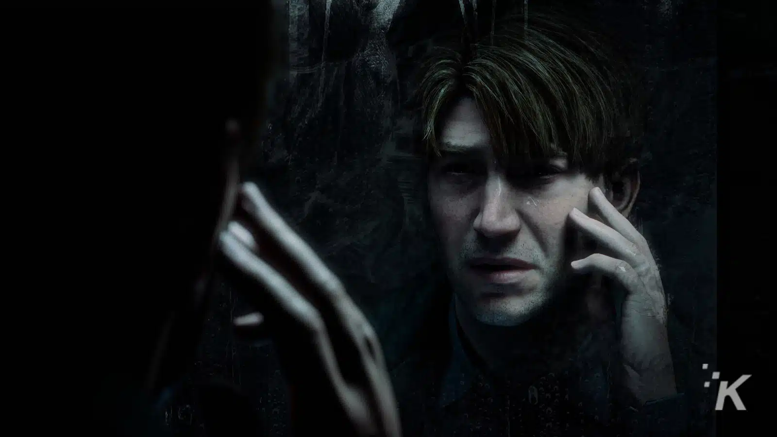 Man reflecting on dark, moody background.