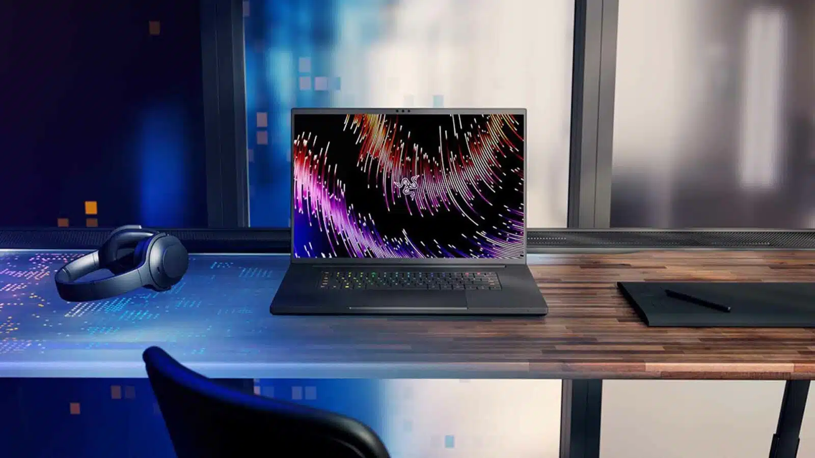 Modern laptop with vibrant screen and headphones on desk.