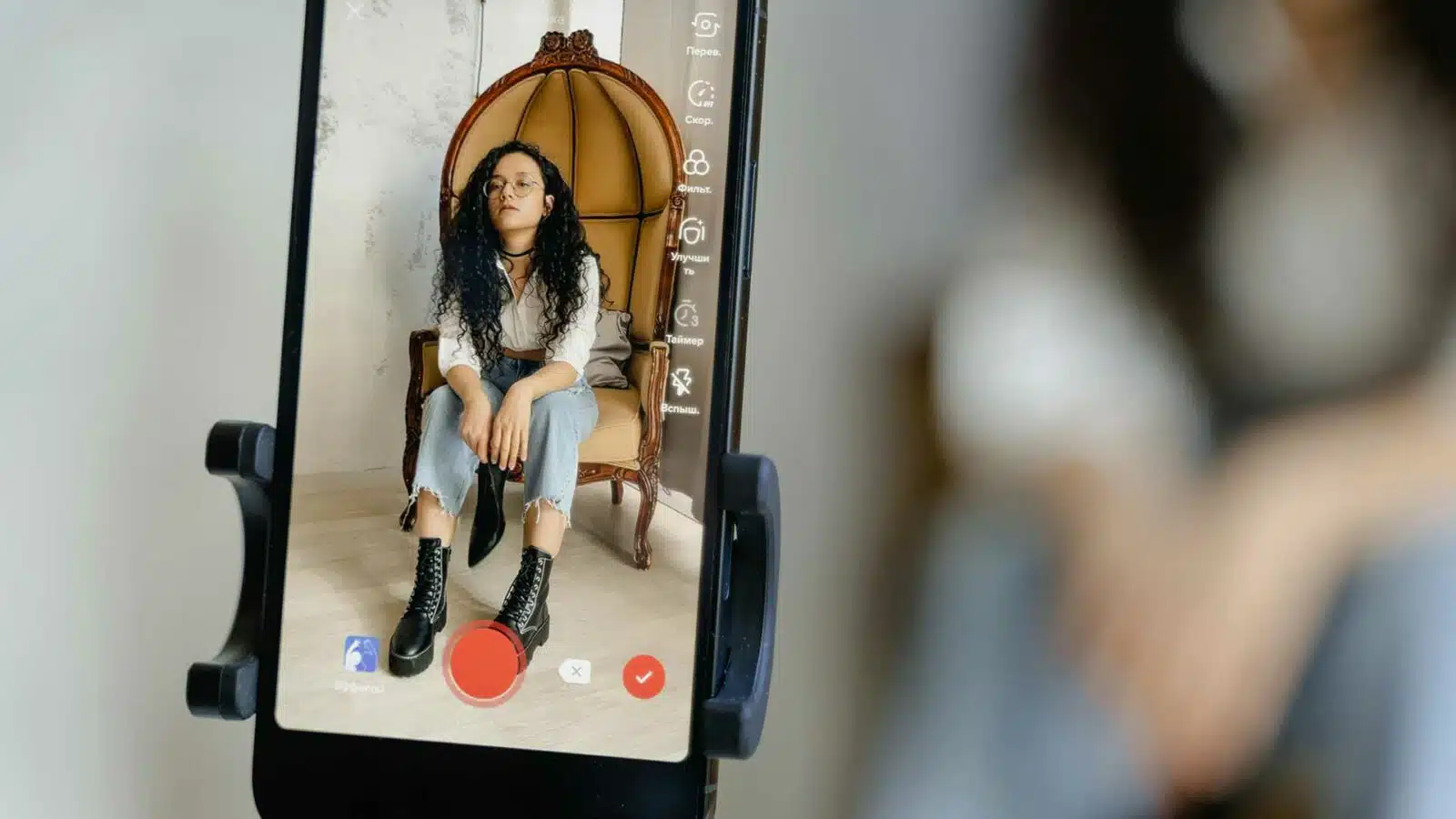 Person in chair viewed through smartphone camera app.