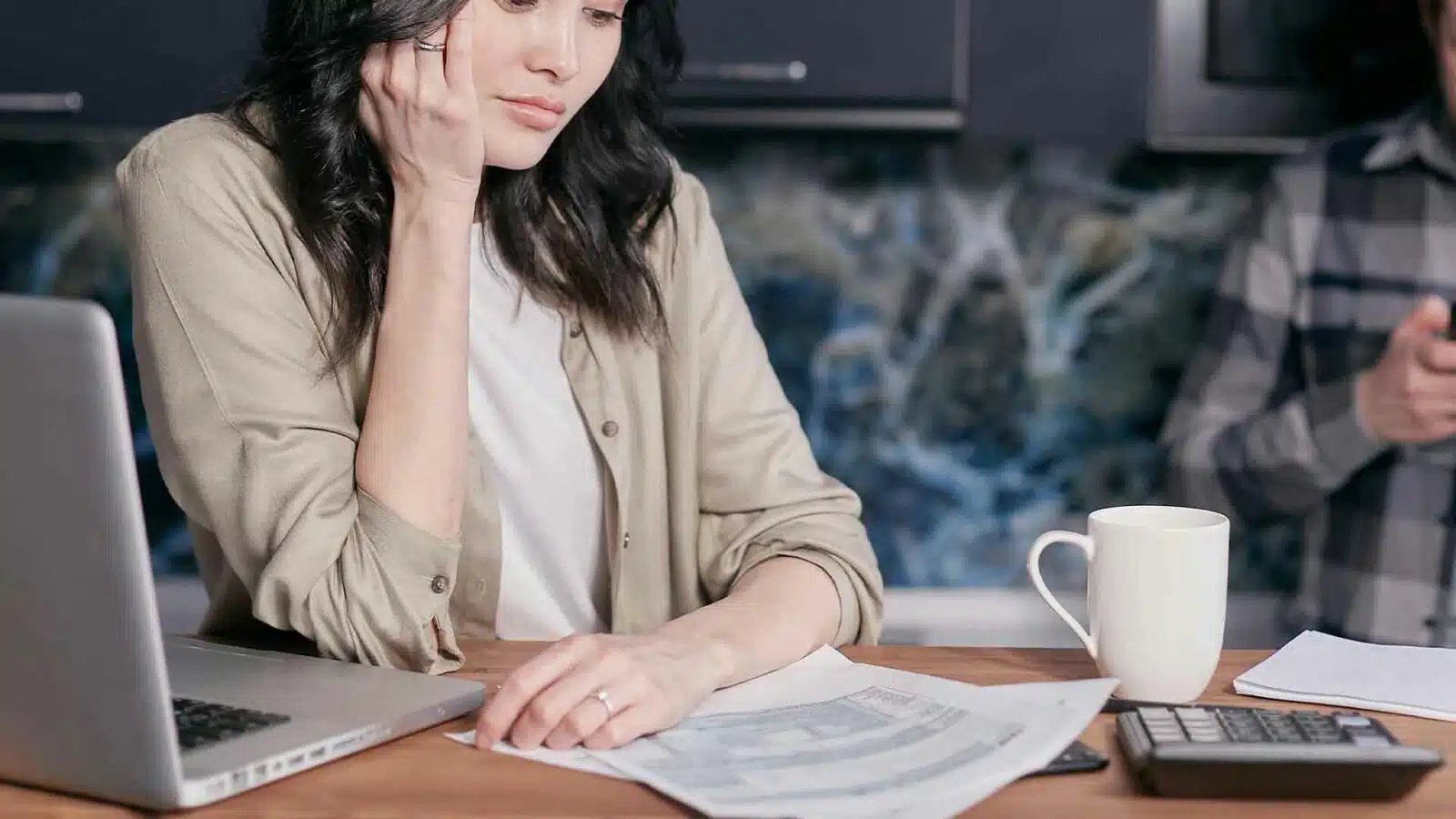 Focused woman reviewing documents at office desk.
