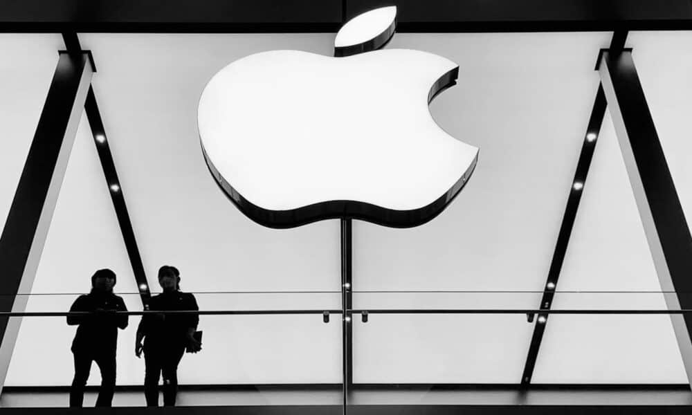 People standing under Apple store logo