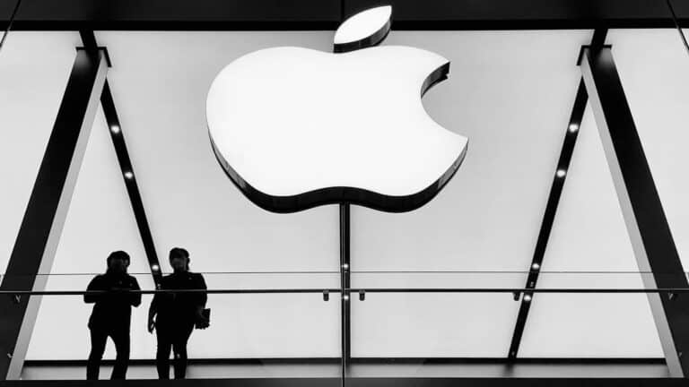 People standing under Apple store logo