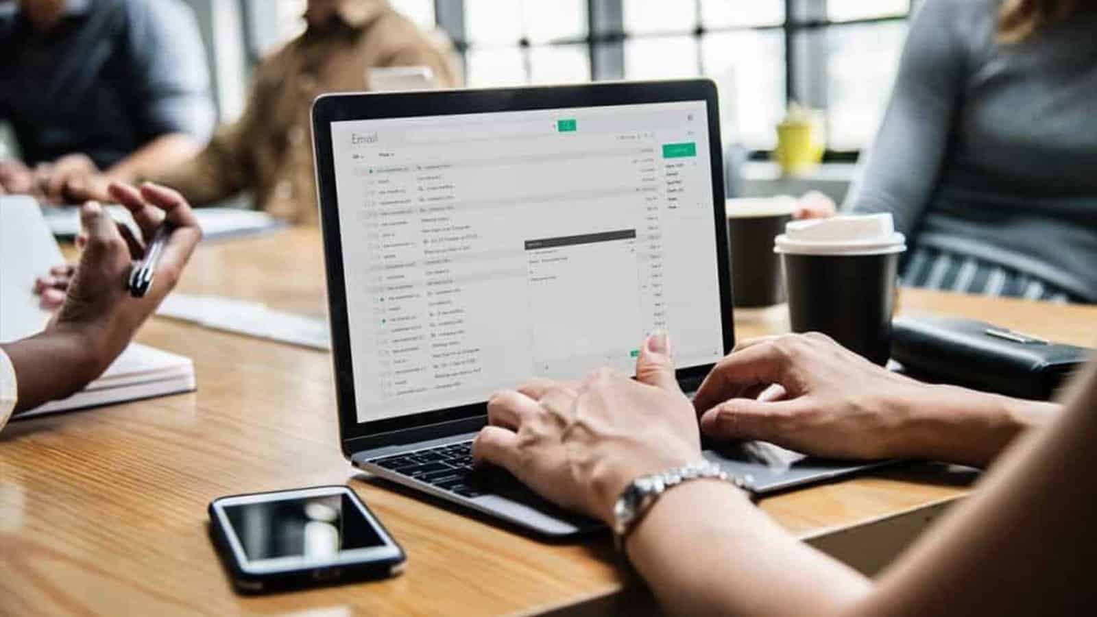 Person typing on laptop in meeting room