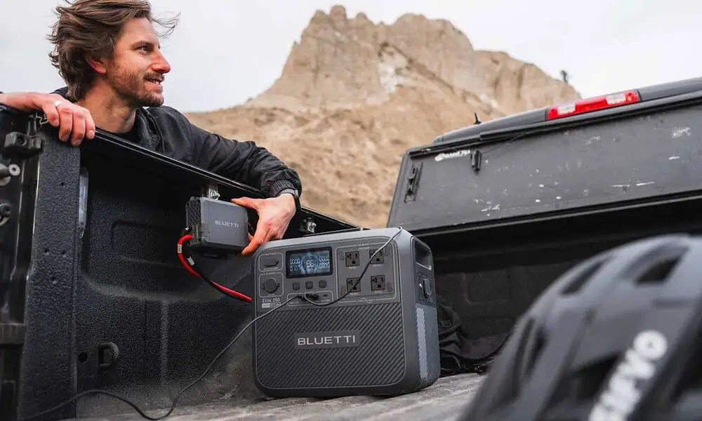 Person with portable power station in truck bed.