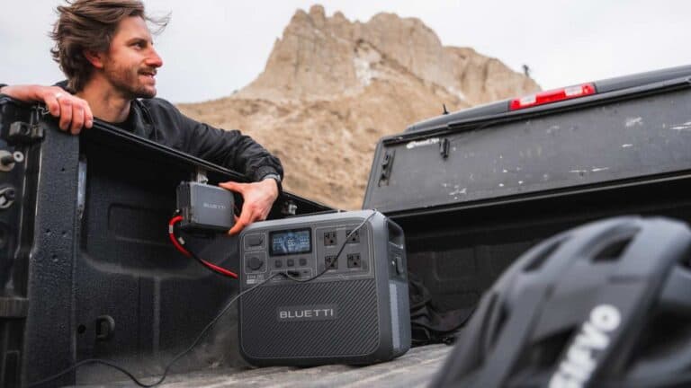 Person with portable power station in truck bed.