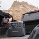 Person with portable power station in truck bed.