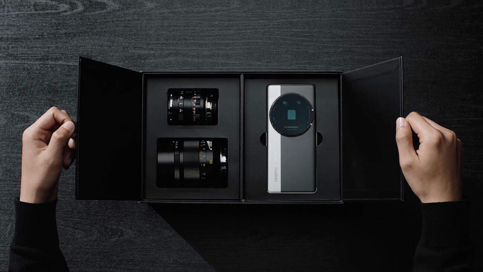 Smartphone with camera lenses in box, dark background.