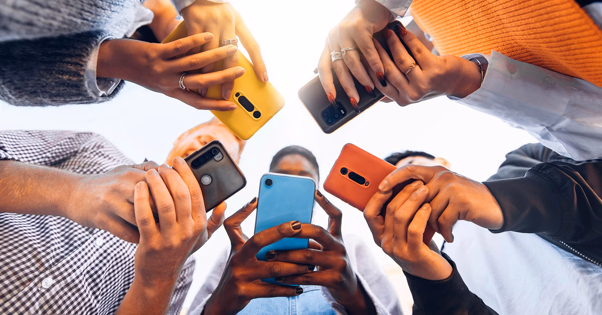 Diverse group holding smartphones in a circle