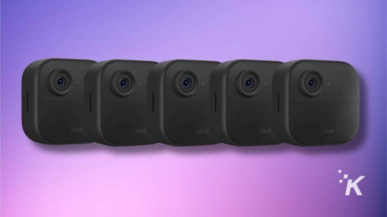 Five black security cameras on purple background.