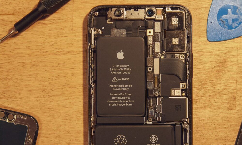 Disassembled smartphone showing internal battery and components.