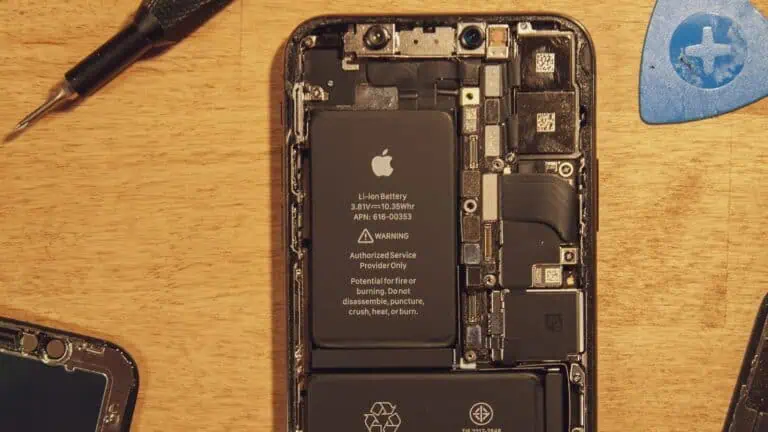 Disassembled smartphone showing internal battery and components.