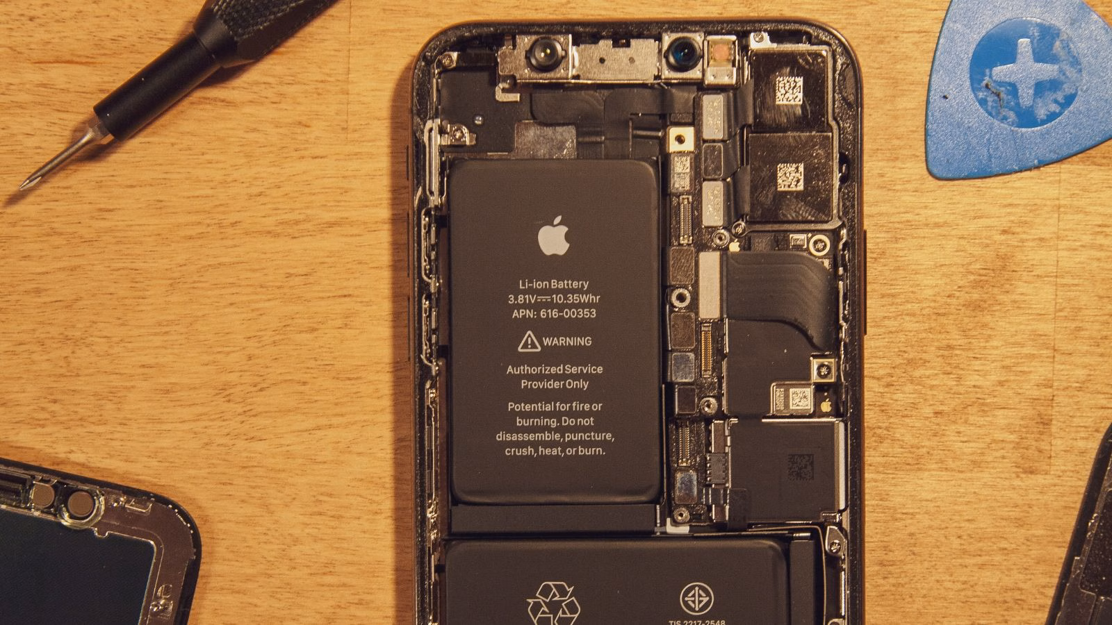 Disassembled smartphone showing internal battery and components.
