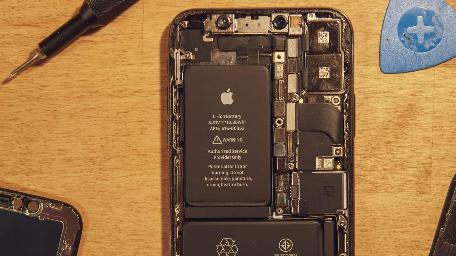 Disassembled smartphone showing internal battery and components.