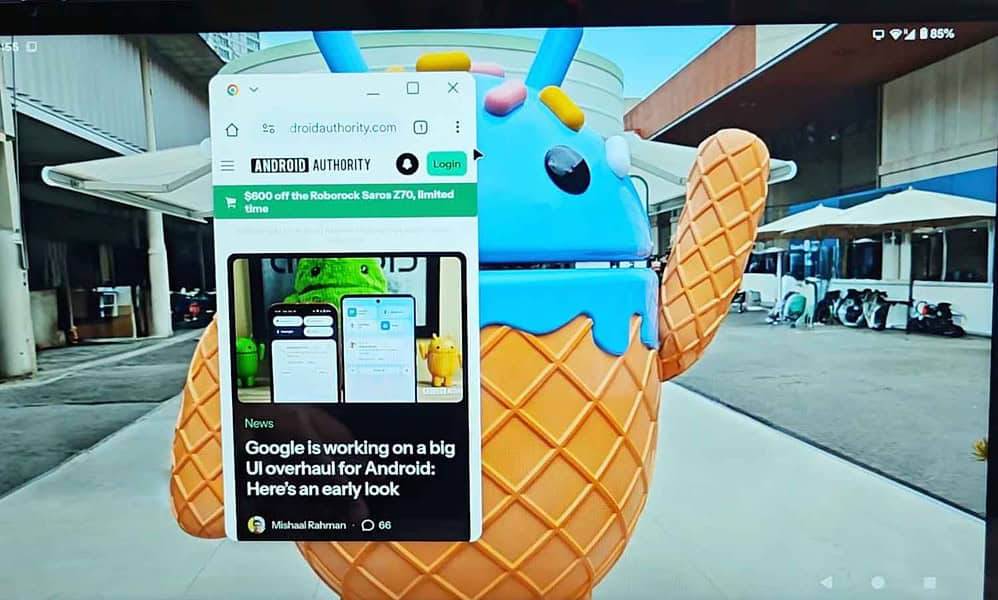 Android webpage open on laptop screen near statue.