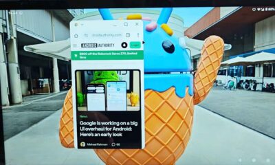 Android webpage open on laptop screen near statue.