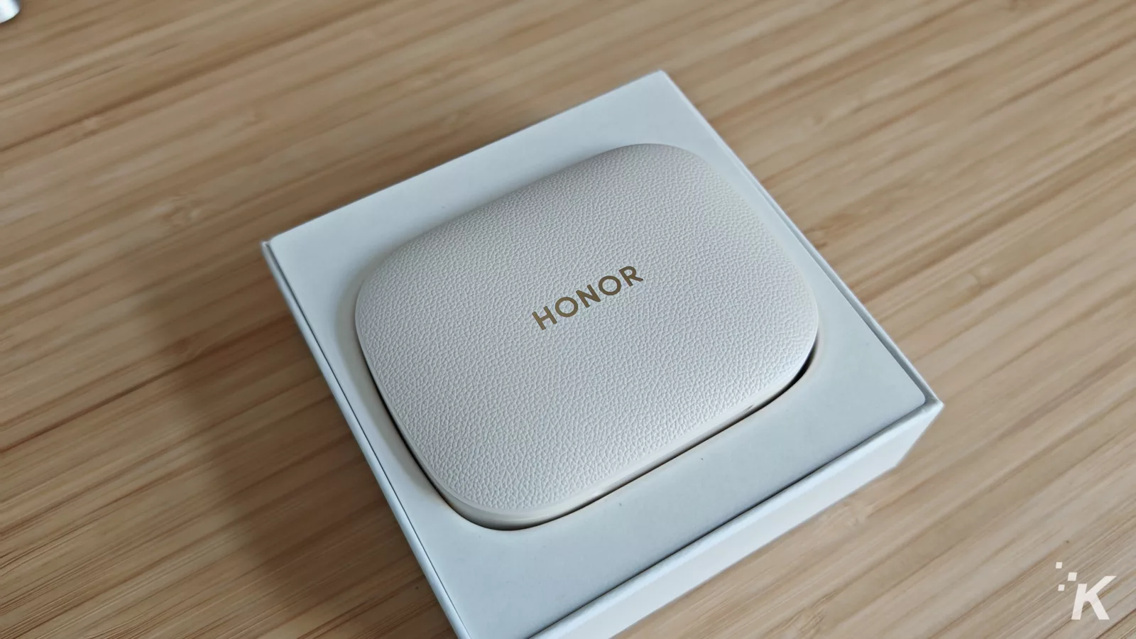 Honor earbuds case on wooden surface