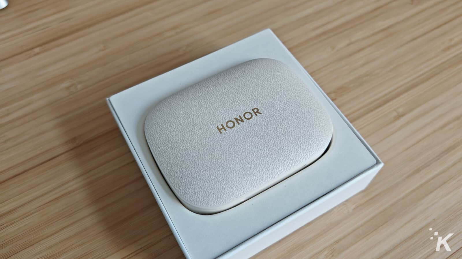 Honor earbuds case on wooden surface