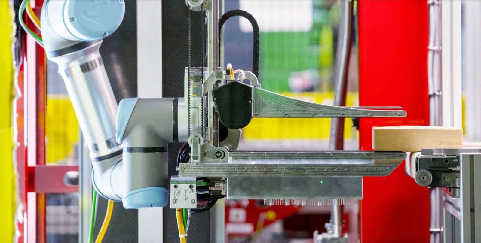 Robotic arm handling box in automated process