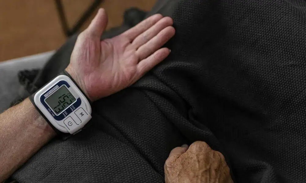 Wrist blood pressure monitor on person's arm.