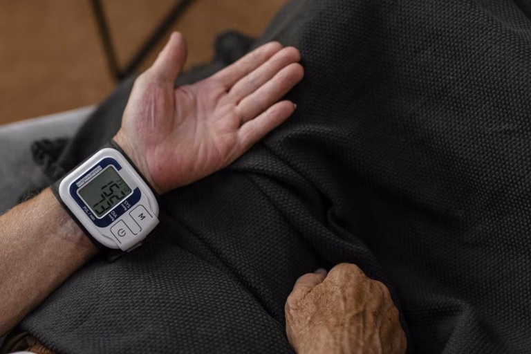 Wrist blood pressure monitor on person's arm.