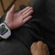 Wrist blood pressure monitor on person's arm.