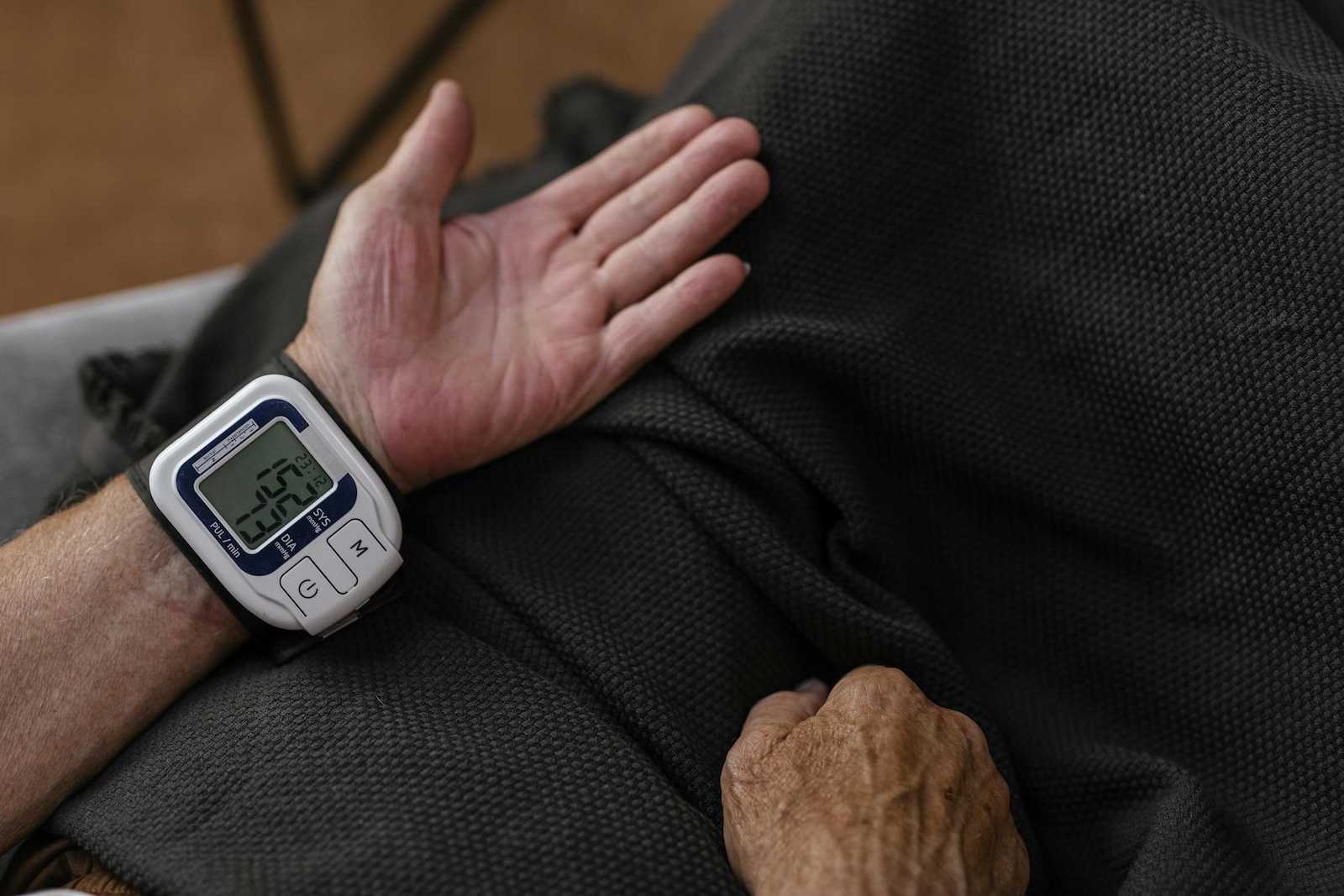 Wrist blood pressure monitor on person's arm.