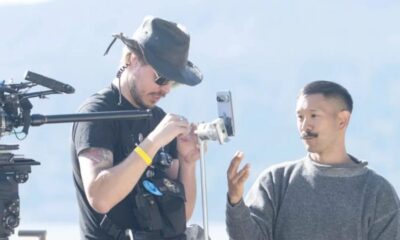 Filmmakers setting up camera equipment outdoors.