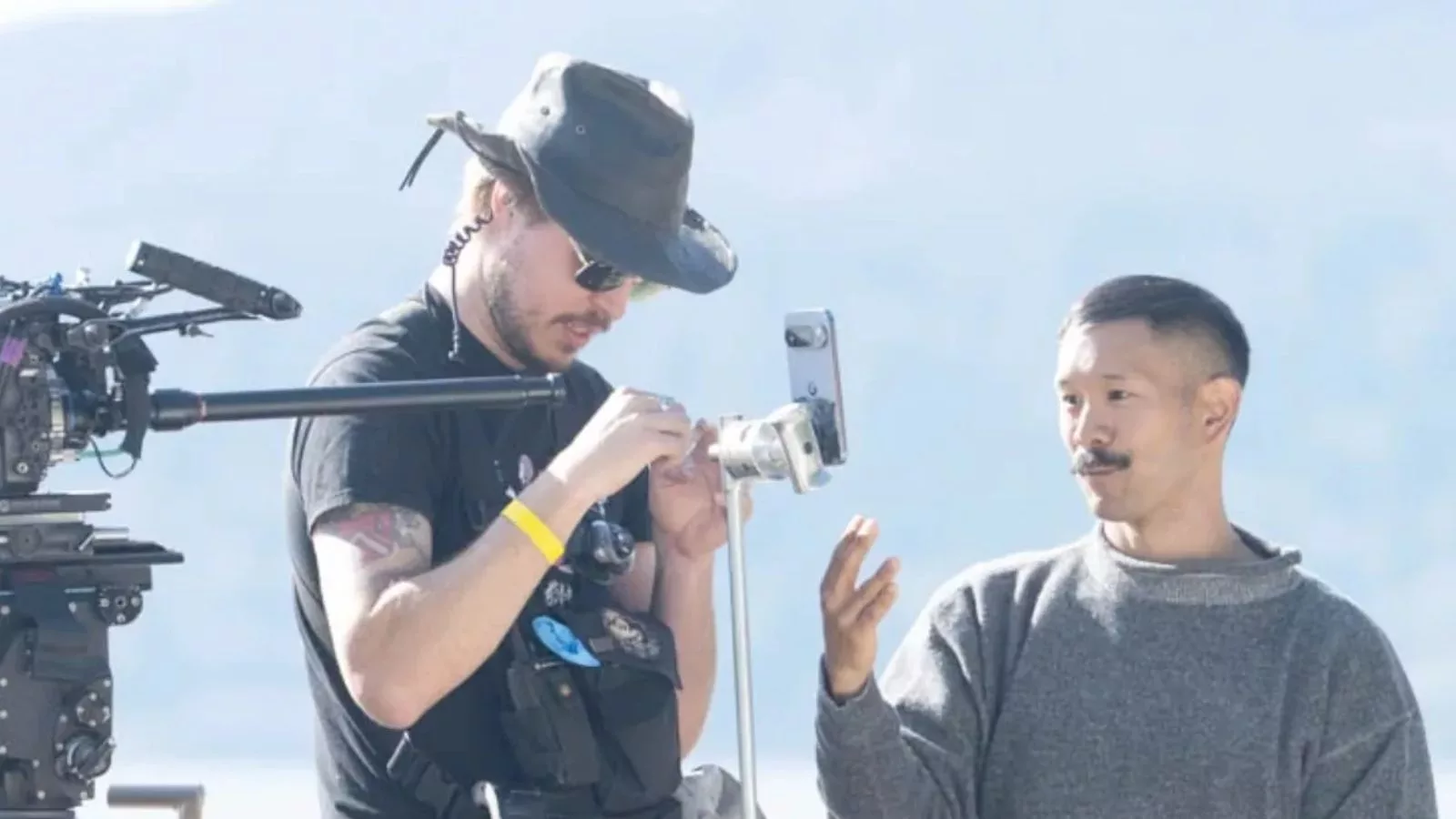 Filmmakers setting up camera equipment outdoors.
