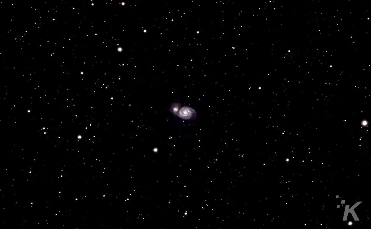Two galaxies colliding in starry night sky