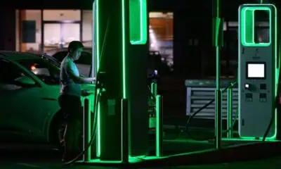 Person charging electric car at night station