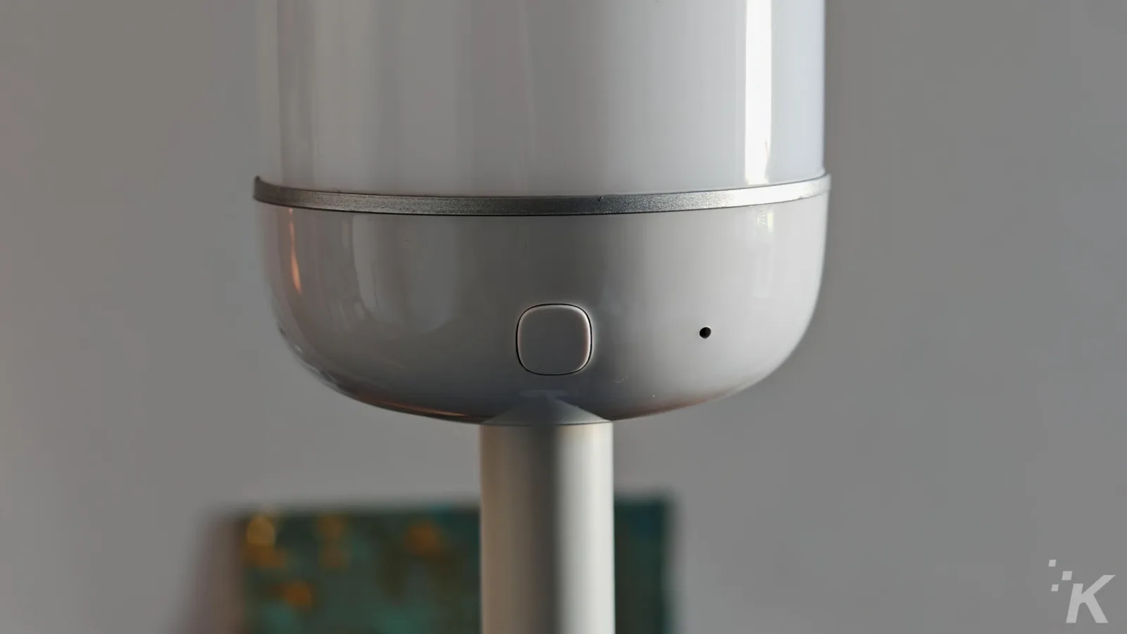Smart lamp base with control button close-up.