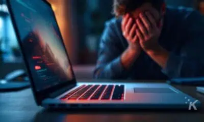 Frustrated person near laptop with error screen.