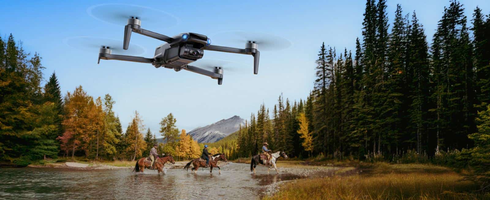 Drone flying above horseback riders in forest