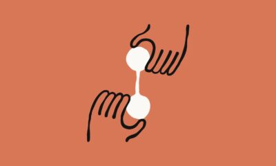 Abstract hands holding white spheres on orange background.