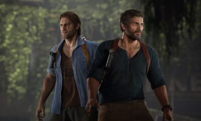 Two men standing with intense expressions in forest.