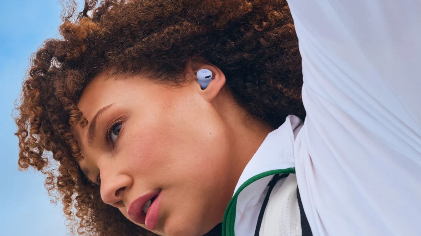 Person wearing wireless earbuds during outdoor activity.