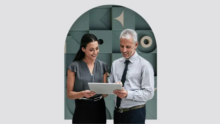 Two professionals discussing content on a tablet.