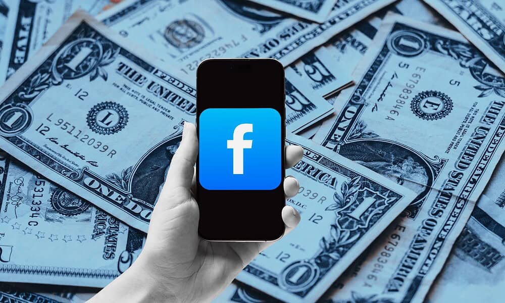 Smartphone with Facebook logo on dollar bills background