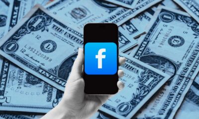 Smartphone with Facebook logo on dollar bills background
