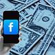 Smartphone with Facebook logo on dollar bills background