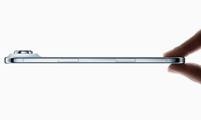 Side view of thin smartphone held with fingers.