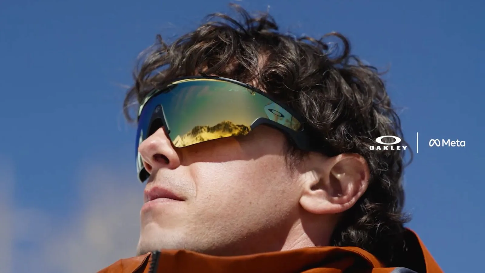 Close-up of man wearing reflective sunglasses outdoors.