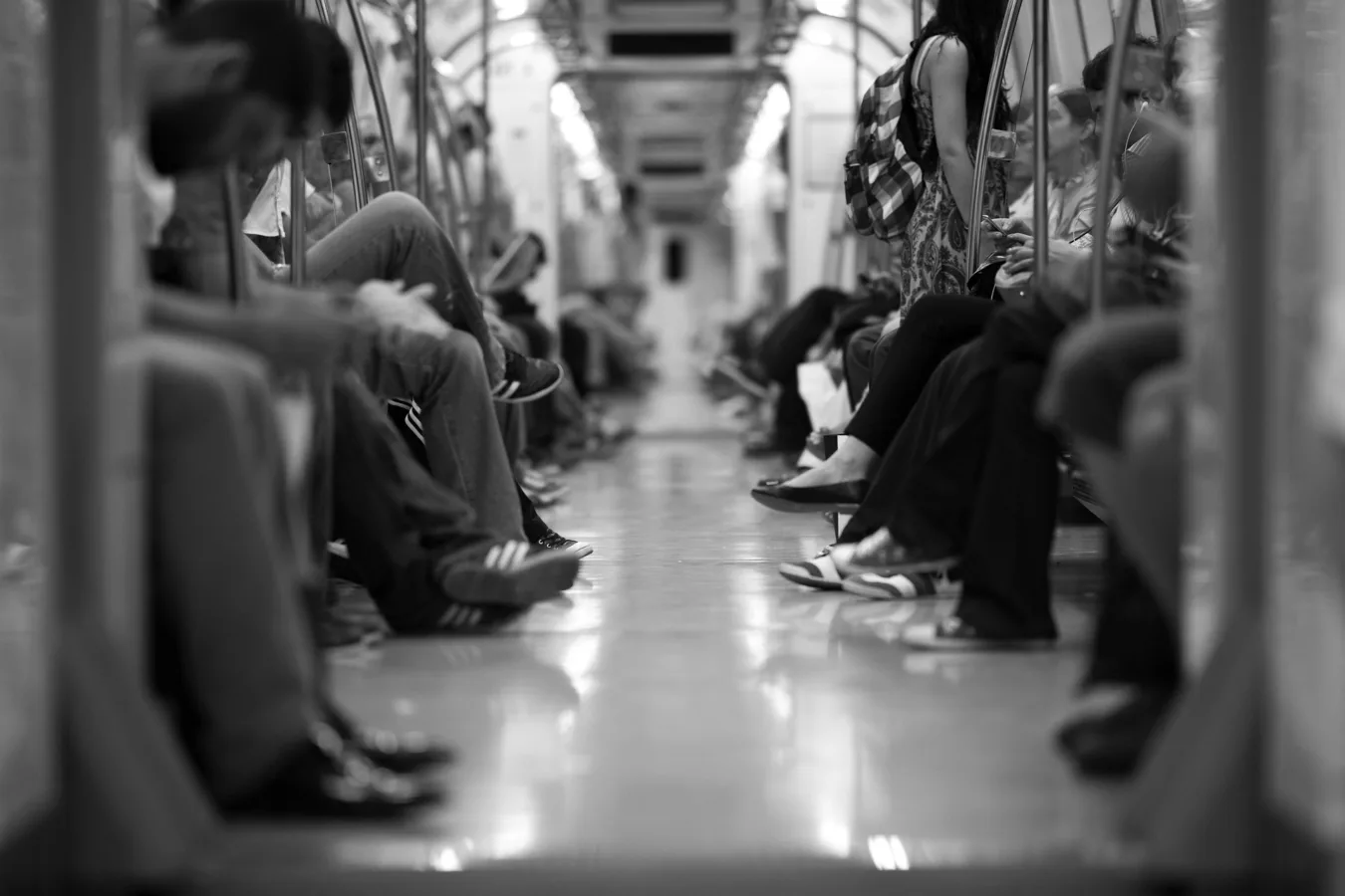 People sitting in subway car, black and white photo.